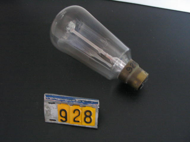  Collection ASPEG, pièce numéro 928 : Ampoule avec douille laiton baïonnette sur support 1871